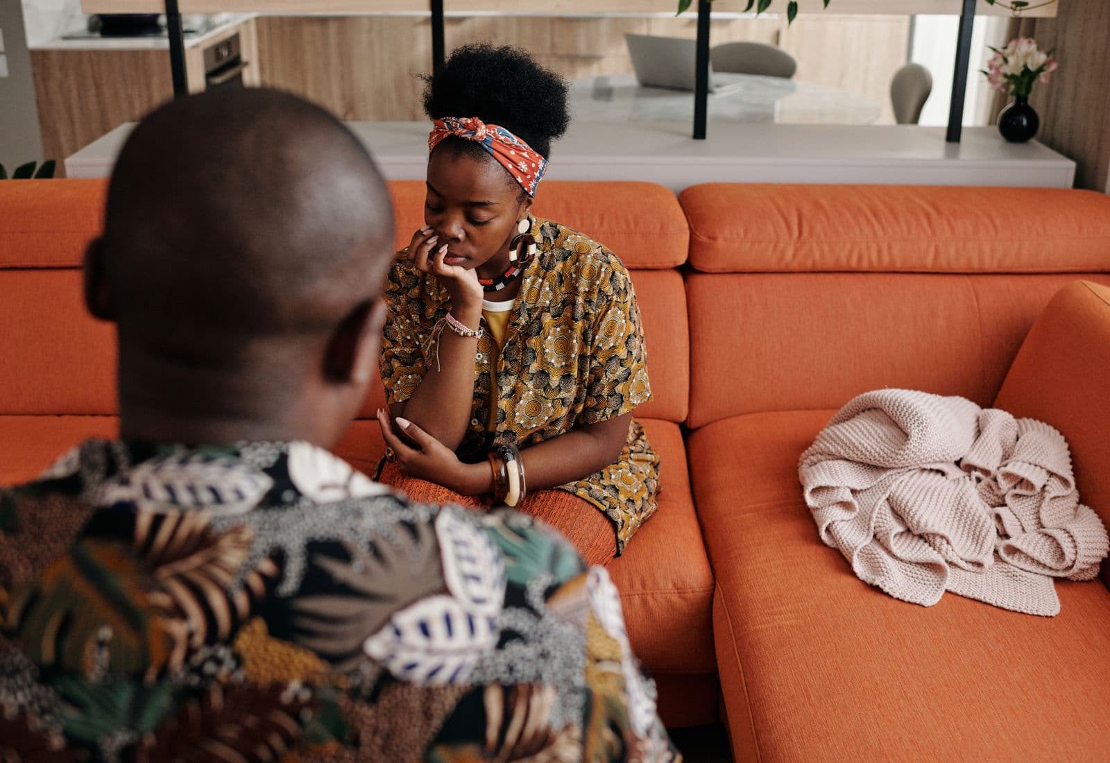 A couple sitting close on a sofa, listening to one another