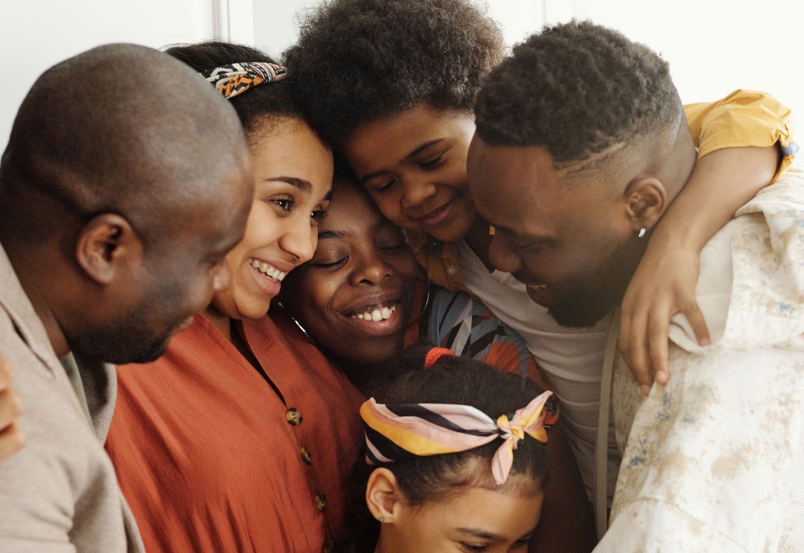 A family of five leaning into one another in a warm embrace